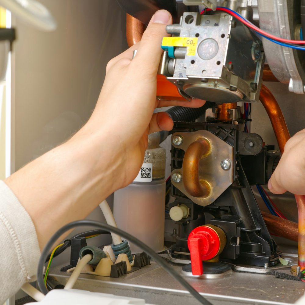 Technician servicing or Repair of a gas boiler, setting up and servicing. gas boiler for heating Technician servicing or Repair of a gas boiler, setting up and servicing. gas boiler for heating